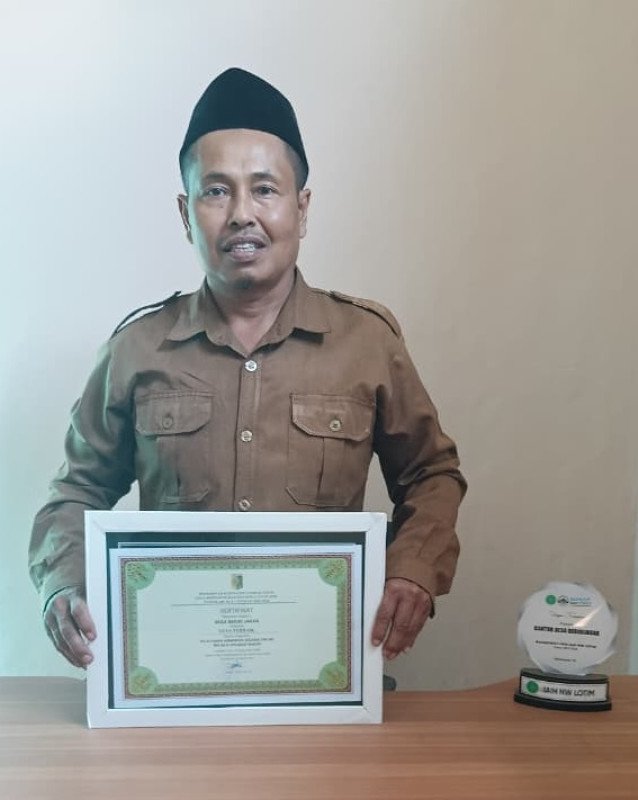 Foto Pj. Kades Beririjarak, H. Lalu Muktar, S.Kep Saat Memegang Sertifikat Penghargaan 